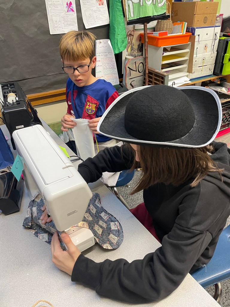 Child in pirate hat sewing
